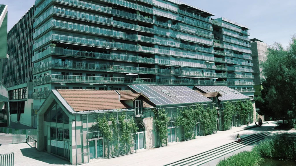 Image d'un bâtiment résidentiel moderne avec des panneaux solaires installés sur le toit, illustrant l'intégration des énergies renouvelables dans un environnement urbain.