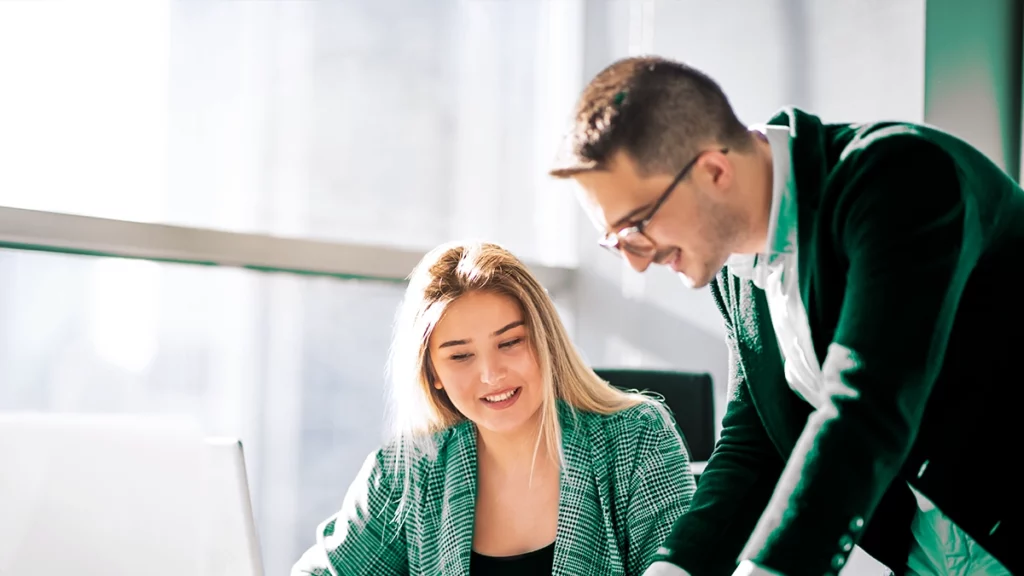 Deux employés collaborant dans un bureau lumineux, illustrant l'importance d'un environnement de travail agréable et économe en énergie.