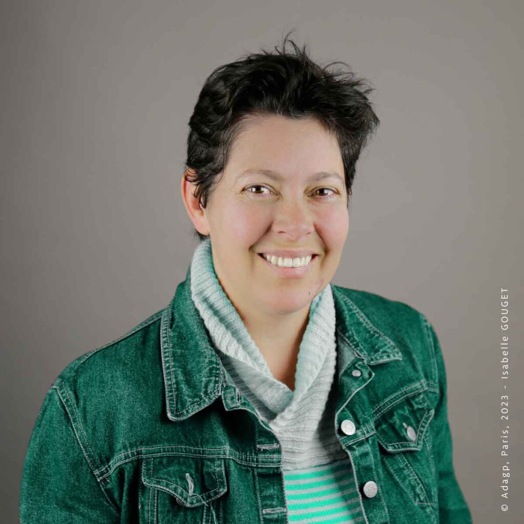 Portrait d'Isabelle GOUGET, fondatrice d'ÉcoConnaissance, souriant en veste en jean verte.